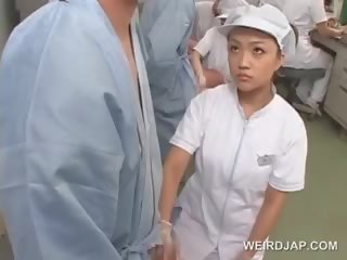 Otäck asiatiskapojke sjuksköterska gnuggning henne patients starved sticka
